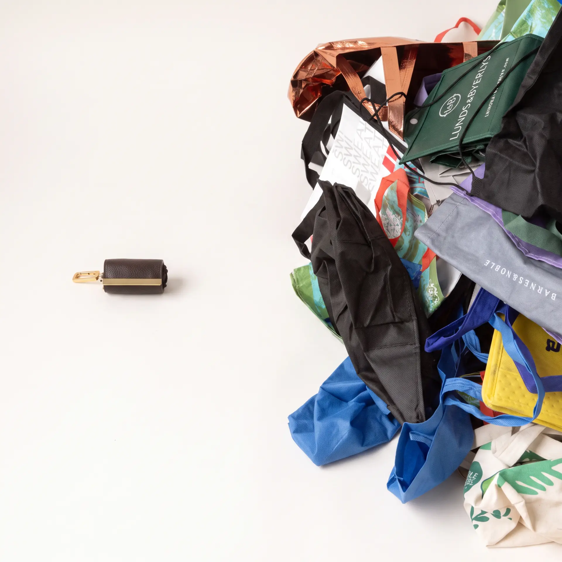 One folded cliptote pouch beside a pile of disposable shopping bags