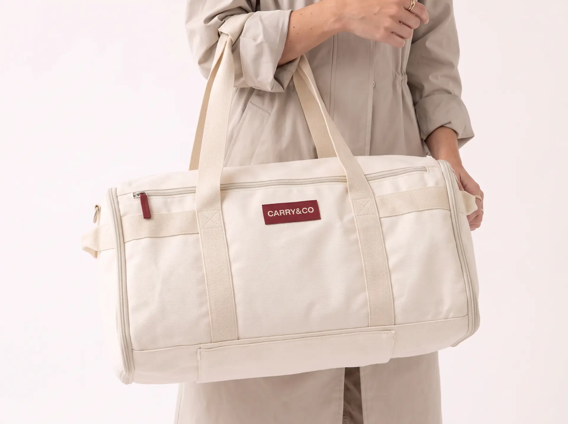 Close-up of the cream Voyager canvas, zippers and leather logo patch