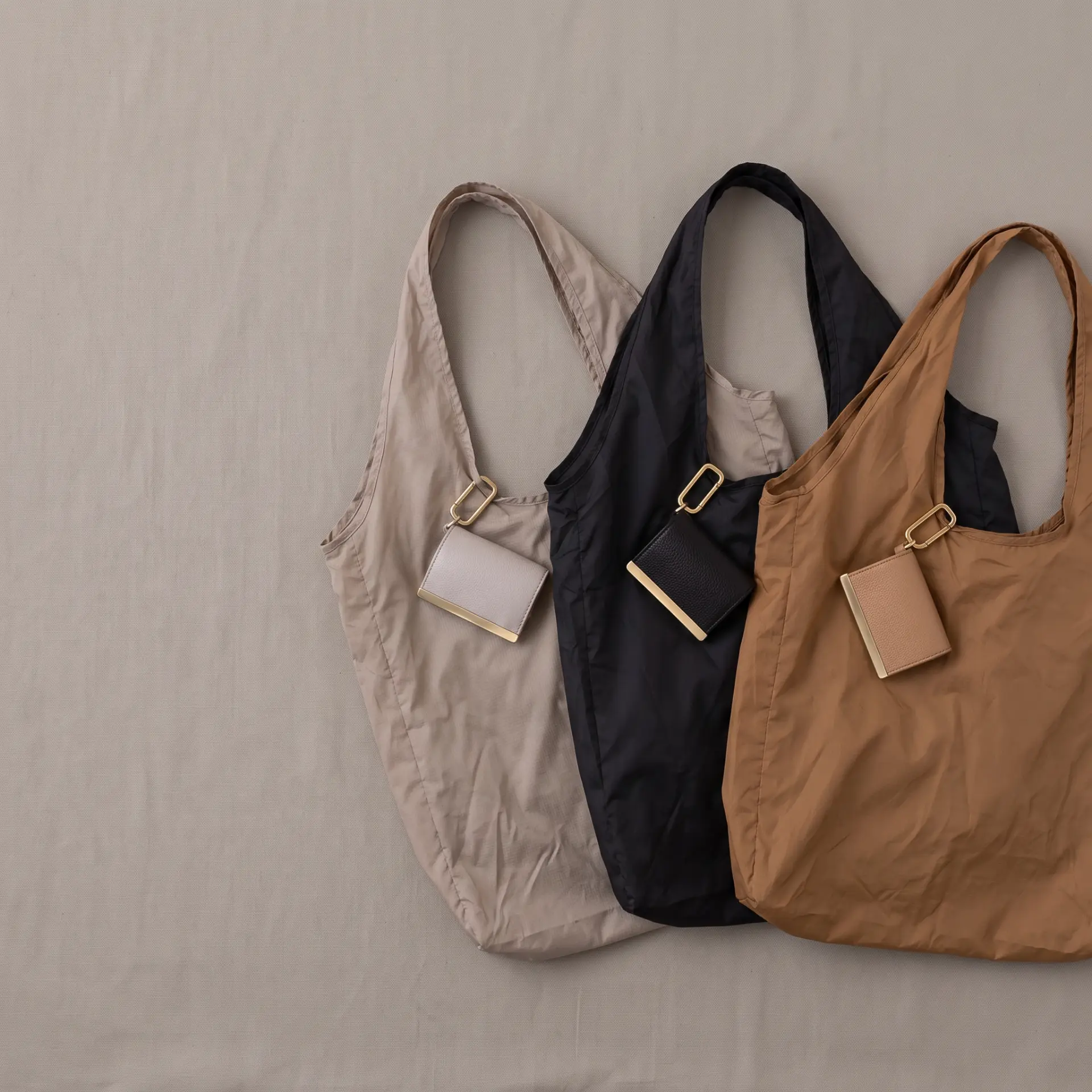 Three cliptote colourways laid flat with their leather pouches